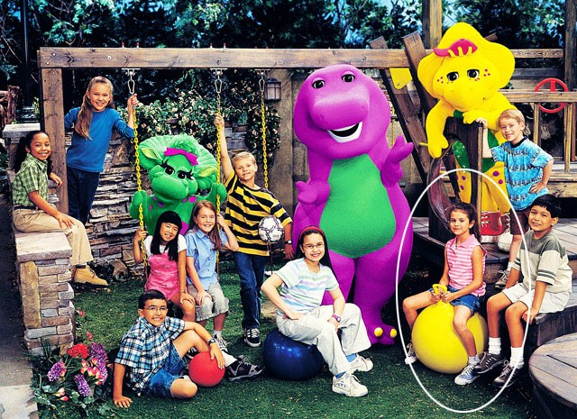 Hình ảnh Selena Gomez năm 2004, lúc 12 tuổi khi tham gia show truyền hình " Barney &amp; Friends" (Selena mặc áo kẻ hồng, ngồi trên quả bóng vàng). Selena đã tham gia show này từ năm cô 10 tuổi, cùng với cô bạn Demi Lovato.